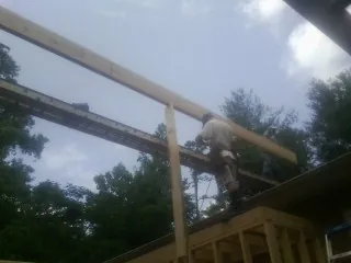 Carpenter setting a ridge beam over a new addition frame — Ice Dam Removal by Roofing Brothers in Paskenta