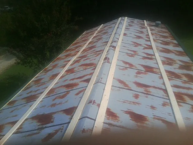 Rusted metal roof panels with new wood purlins before replacement — Storm Damage Roof Repair in Paskenta by Roofing Brothers
